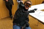 Botschafterin Judit im Klassenzimmer mit Knieschonern, Skibrille und Handgelenksschonern