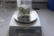 Auf der Waage steht ein Reagenzglas mit Spültuchprobe