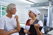 Zwei Frauen im Gespräch in einer Wäscherei