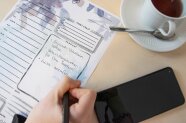 Person schreibt etwas in eine To-do-Liste