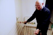 Senior hängt Wäsche an einen Wäscheständer