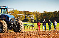 Personen mit Traktor auf einem Acker