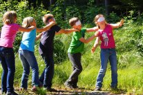 Kinder mit verbundenen Augen im Wald