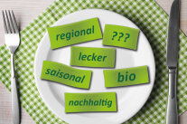 Zettel mit Aufschriften wie regional, lecker, bio, nachhaltig auf einem Teller