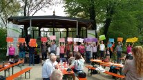 Eine größere Personengruppe präsentiert vor Publikum die Namen der Kirchen vom Simultankirchen-Radweg. 