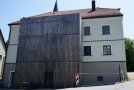 Rückwärtige Ansicht des sanierten Gasthausgebäudes mit modernem Anbau der sich durch seine Lärchenschalung vom historischen Putzbau absetzt