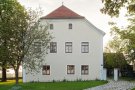 Saniertes Hofmarkschloss, Dachgeschoss mit Krüppelwalm. Fassade cremefarben, alle Fenster und Lisenen weiss hervorgehoben