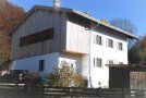 Pultdachanbau an die ehemalige Schule im ersten Stock mit Holz verkleidet. Die Fenster des Anbaus nehmen die Höhenlage der alten Einzelfenster auf und sind mit einer Holzlamellenschicht verkleidet