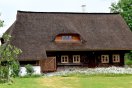 Tagwerkerhaus in Blockbauweise mit großflächigem Schilfdach mit Fledermausgaube