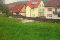 Betonwand schützt Häuser vor vorbeifließendem Hochwasser.