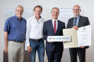 Drei Männer mit Urkunde