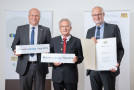 Drei Männer mit Urkunde