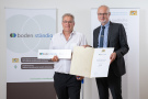 Zwei Männer mit Urkunde