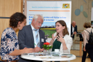 Drei Personen tauschen sich an einem Stehtisch vor einem Exponat zum Projekt aus 