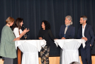 Vier Personen, die einen Vortrag gehalten haben, an zwei Stehtischen im Podiumsgespräch mit Moderatorin 