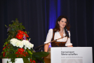 Frau Ministerin am Rednerpult; Tagungsmotto sichtbar; Blumengesteck