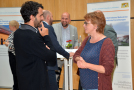 Fünf Personen tauschen sich an und vor einem Stehtisch vor einem Exponat zum Projekt aus