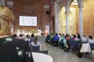 Frauen sitzen in der Allerheiligenhof-Kirche und hören der Rede der Ministerin zu.