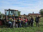 Schulklasse auf einer Wiese vor einem Traktor (Foto: Sieglinde Pollan)