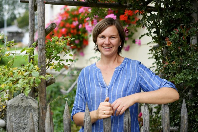 Frau steht am Gartenzaun ihres Hausgartens (Foto: Warmuth/StMELF)