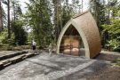 Interessant geformtes, kleineres Holzbauwerk inmitten eines Kiefernwaldes