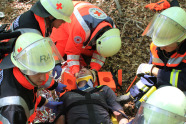 Sanitäter versogen einen verletzten Mann mit Halskrause auf einer Trage (Foto: Martin Kolbe).