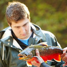 Junger Mann begutachtet einen Fisch