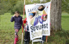 Kinder schauen durch vorgeformte Löcher im Steuobstplakat