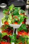 Angerichteter Salat in kleinen Schüsseln, die pyramidenförmig übereinander stehen.