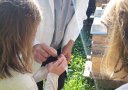 Kind und imker am Bienenstand