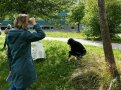 Personen im Gelände, eine schaut durch ein Fernglas.