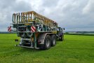 Ein Schlepper mit Güllefass steht auf der Wiese.