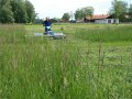 Person mäht mit der Stachelwalze eine Wiese