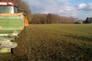 Schlepper mit Mineraldüngerstreuer am Feldrand