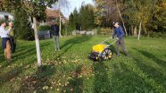 Person auf einer Streuobstwiese mit einer Erntemaschine zum Schieben.