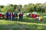 Personengruppe auf einer Streuobstwiese bei einer Vorführung von Obsterntemaschinen-