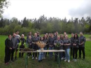 Gruppenfoto auf landwirtschaftlichem Acker mit Spatenprobe und Getreideähren