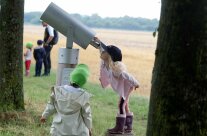 Kinder schauen durch ein großes Fernrohr