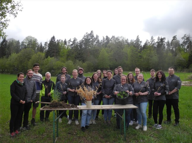 Gruppenfoto auf landwirtschaftlichem Acker mit Spatenprobe und Getreideähren
