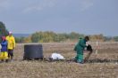 Mehrere Personen bringen per Hand Biokohle auf einem Feld aus