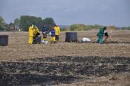 Personen bei der Ausbringung von Biokohle auf einem Feld.