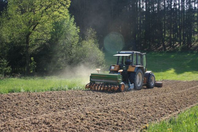 Drillmaschine bei der Ansaat auf einem gefrästen Streifen im Grünland.