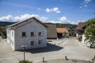 Saubere Straße mit mehreren Häusern in ländlicher Lage. Im Vordergrund ein Haus mit neuer Steinfassade.