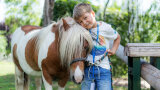 Ein glücklicher Junge mit geschecktem Pony.