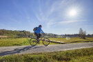 Mountainbikerin auf einem Schotterweg im Voralpenland