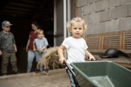 Kinder helfen auf einem Bauernhof bei der Stallarbeit