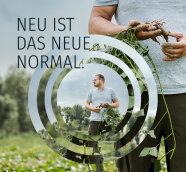 Mann auf dem Feld mit einer Pflanze mit Wurzel in der Hand. Text: Neu ist das neue Normal.