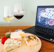 Wein und Käse vor einem Computerbildschirm