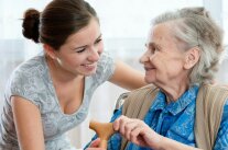 Alte Dame und Pflegerin schauen sich freundlich an