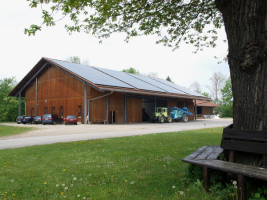 Landwirtschaftliches Gebäude mit einer Photovoltaik-Anlage auf dem Dach.